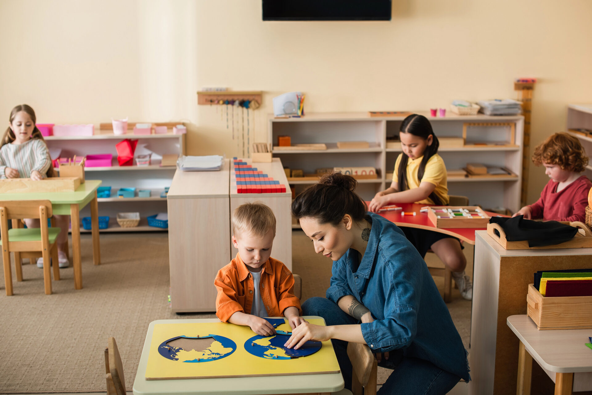 Maestra con niño en actividad de puzzle y aprendizaje