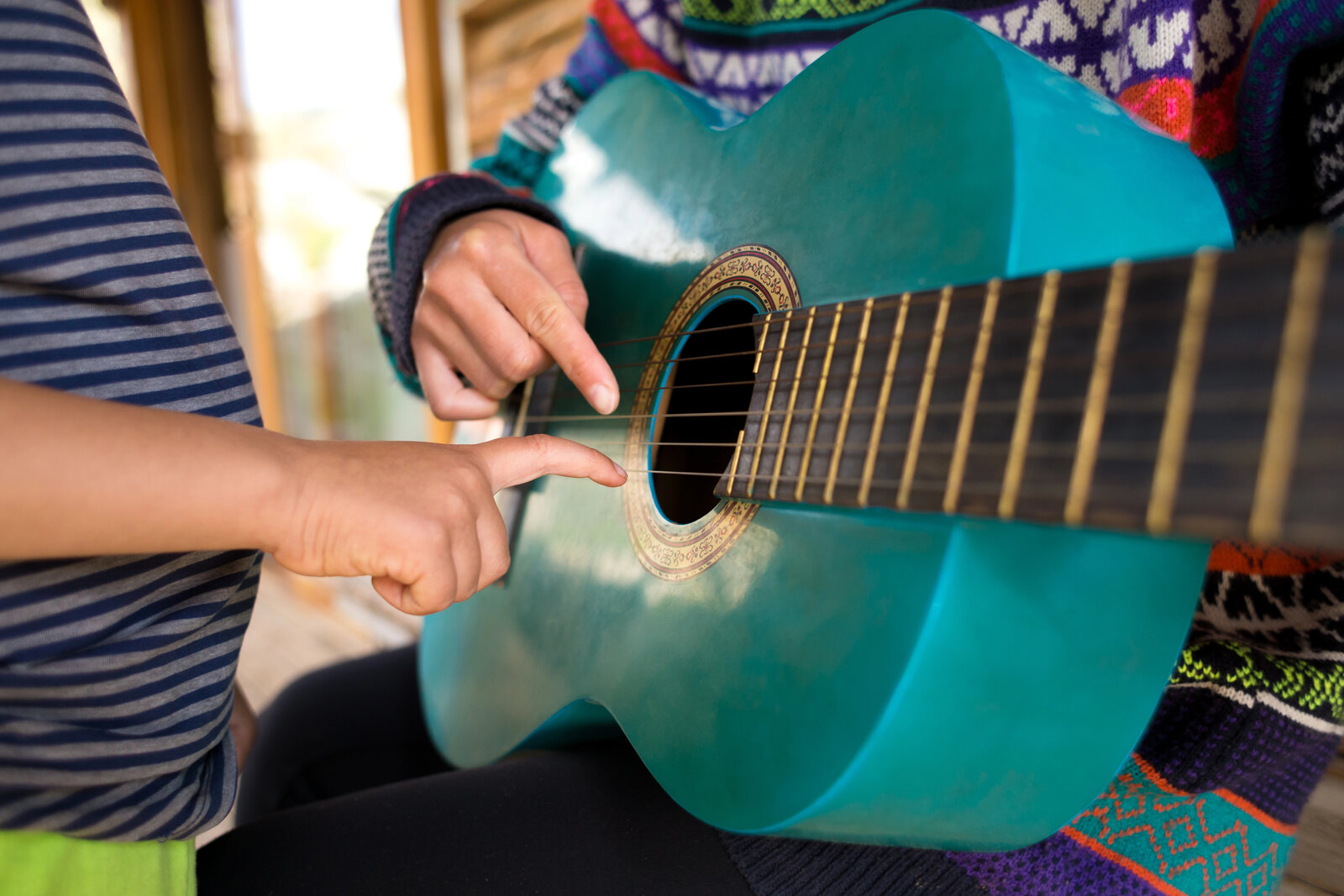 Manos aprendiendo guitarra en clase