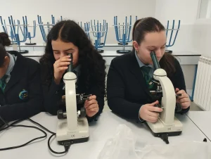 Alumnas de Bachillerato usando el microscopio en el laboratorio del colegio