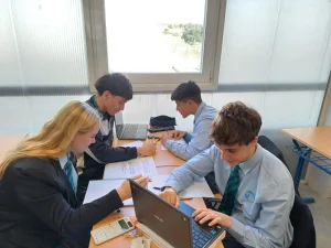 Alumnos de Bachillerato trabajando en equipo con portátiles en el aula