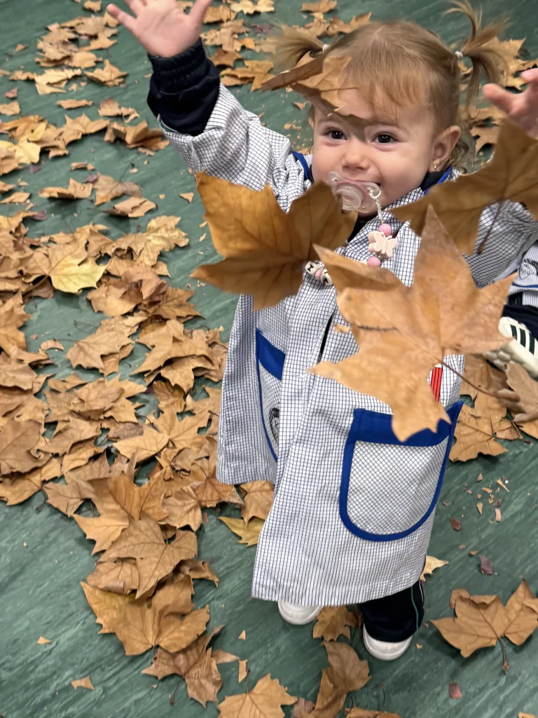 Alumna del CEI KW Pequeñitos jugando con hojas de otoño
