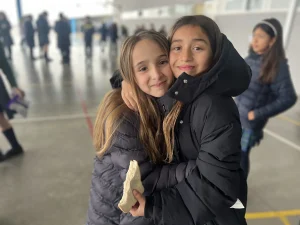Dos alumnas abrazadas en el patio del colegio
