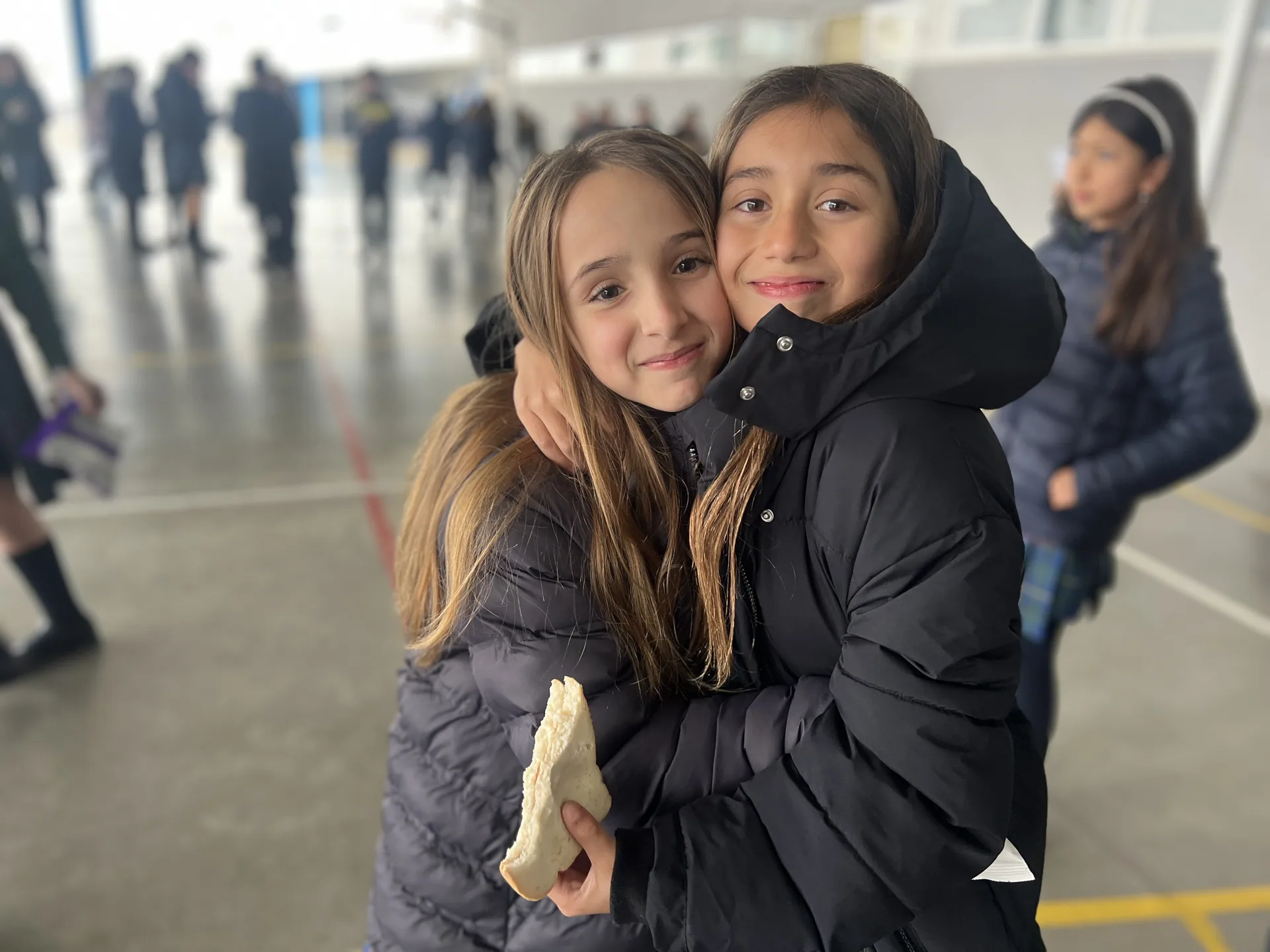 Dos alumnas abrazadas en el patio del colegio