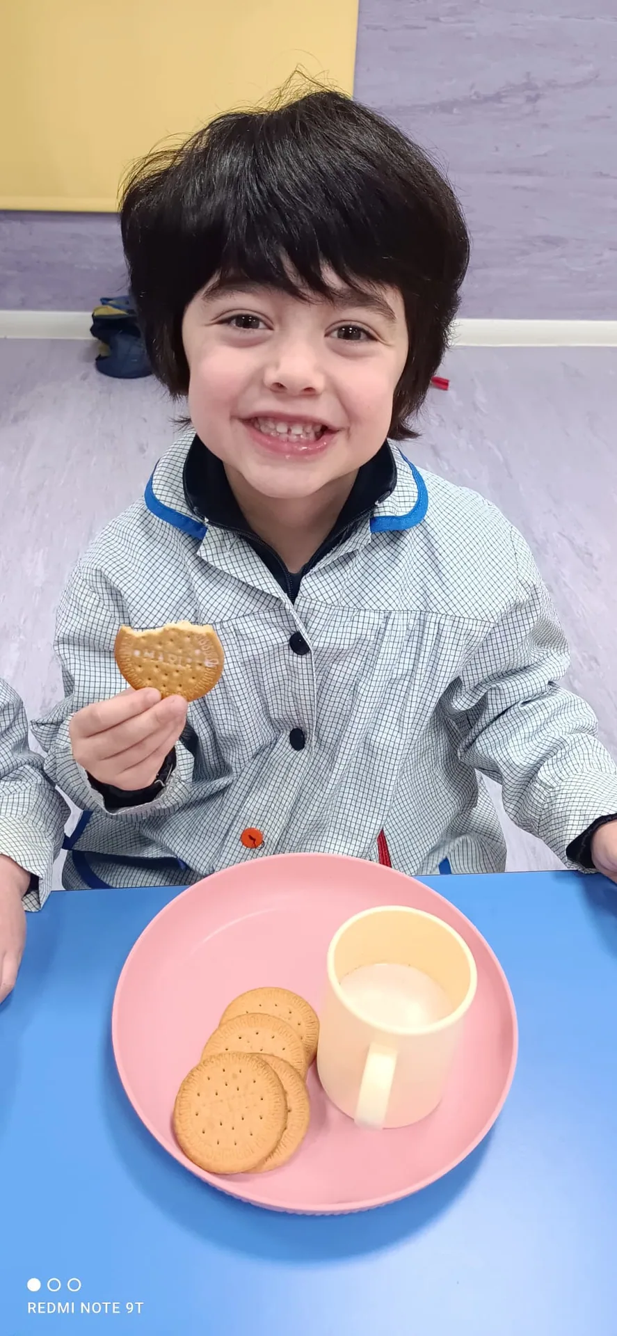 Alumno de Infantil sonriendo durante el desayuno matinal