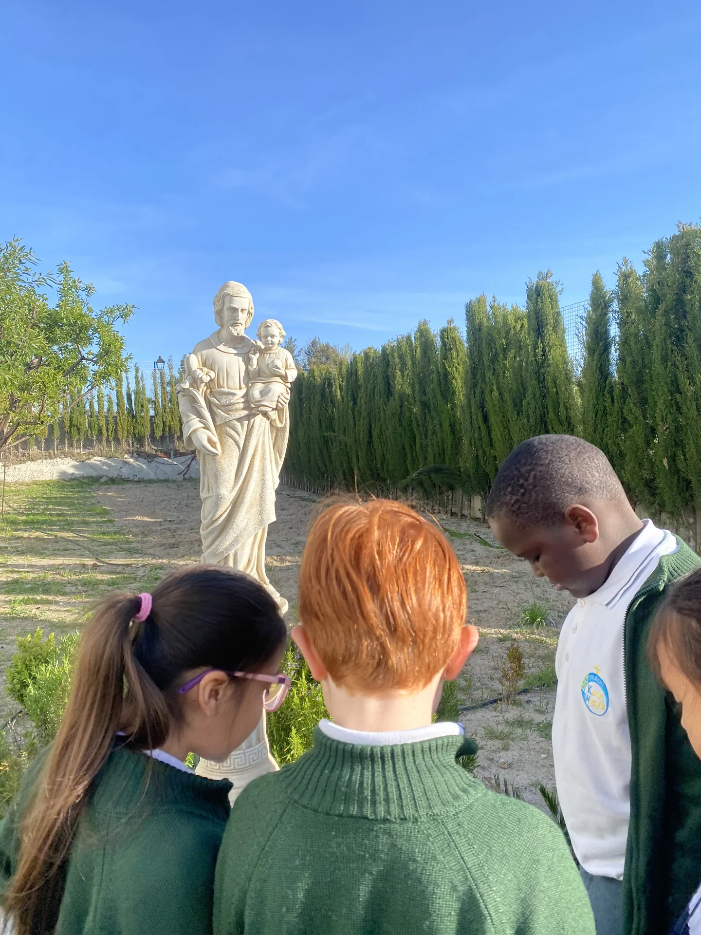 Alumnos ante la estatua de san José en el exterior del colegio