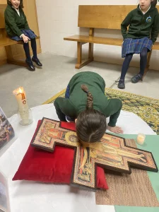Alumna venerando un icono durante una oración en la capilla